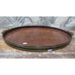 A Georgian mahogany serving tray of oval form, with raised gallery border, brass banding and with