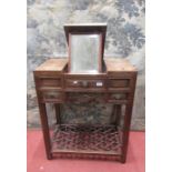 A Chinese hardwood dressing table, the central section enclosing a rising mirror, flanked by two