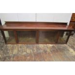 A 19th century mahogany cabinet of horizontal form, enclosed by a pair of glazed panelled doors