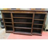 An Edwardian mahogany breakfront bookcase of narrow proportions enclosing an arrangement of