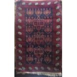 A Persian rug with white and red medallions upon a navy blue ground, 140 x 85cm