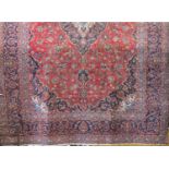 Good quality Hamadan type village Keshan carpet with scrolled floral decoration upon a red ground,