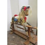 A vintage dapple grey rocking horse on central rocker, overall length 115cm x 95cm high