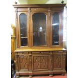A substantial 19th century oak bookcase, the lower section enclosed by three panelled doors and