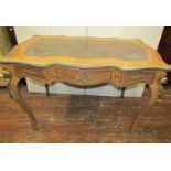 A Louis XV style writing desk of shaped outline, raised on four cabriole supports, enclosing three