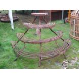 An old weathered ironwork garden/conservatory planter with four graduated bow fronted tiers, 130