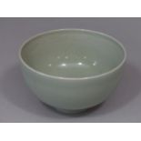 An oriental bowl with celadon glaze with faint incised figures of four male characters to the