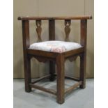 An oak corner chair with moulded rail, pierced vase shaped splats, drop-in upholstered seat and