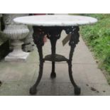 A weathered cast iron Britannia head pub table with swept supports and pierced detail, beneath an