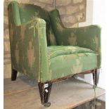 An Edwardian easy chair with shaped outline, upholstered finish and square tapered forelegs, with