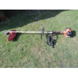 A Tanaka TBC-240 series petrol driven garden strimmer with canvas sling