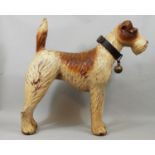 A vintage moulded figure of a terrier with leather collar and brass bell, 46 cm in height