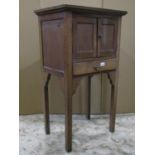 A small oak freestanding side cupboard enclosed by a pair of rectangular panelled doors over a