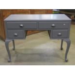 An Edwardian kneehole dressing table fitted with an arrangement of four frieze drawers raised on