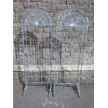 A pair of freestanding light steel flower pot stands of arched form with lattice scroll and