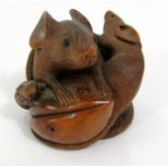 A carved timber Okimono of three rats surrounding a fruit, signed, 6cm
