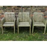 Three matching weathered teak garden chairs with slatted seats, backs and slightly tapered arms,