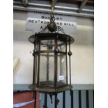 An Edwardian Arts & Crafts style anodised copper hall lantern of hexagonal form with glazed panels