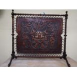An interesting 19th century screen the turned walnut frame, supporting an embossed leather panel,