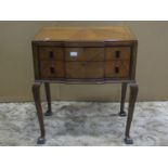 An Art Deco style walnut veneered shallow breakfront two drawer side table with ebonised detail