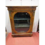 A good quality walnut and figured walnut peer cabinet enclosed by a glazed panel door with string