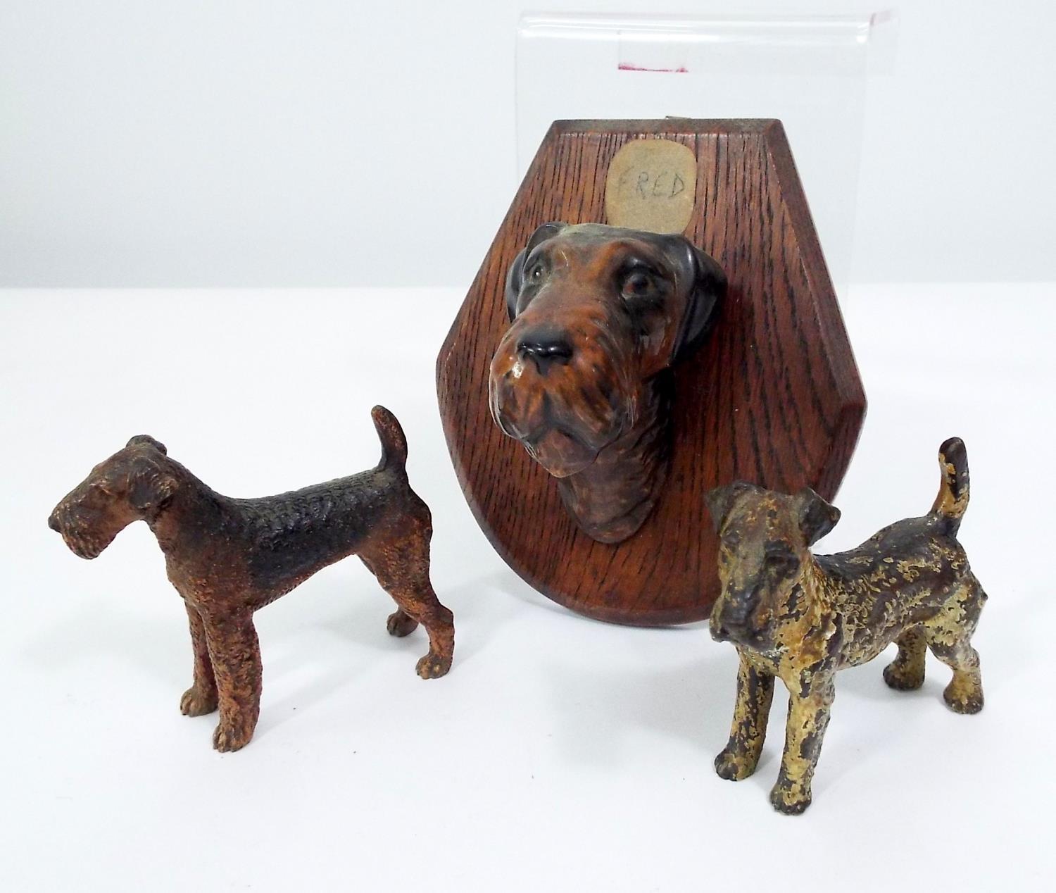 Two cold painted bronze models of fox terriers and a further ceramic fox terrier mask mounted on