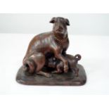 A late 19th century carved Japanese timber figure of a dog being suckled by a piglet-like pup,
