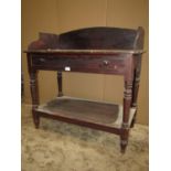 A 19th century stained pine two tier washstand with raised three quarter gallery/splashback over a