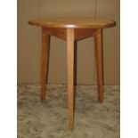 A simple cricket table, the circular pale walnut top raised on oak square tapered supports, 60 cm