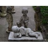 Two matching contemporary garden ornaments in the form of sleeping reclining boys with their dogs