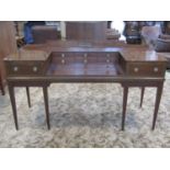 A mahogany desk with inlaid crossbanded detail and central recessed bank of six small drawers,