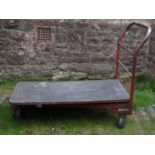 Three industrial hand carts/trollies with wooden flat beds, metal chassis and tubular handles, the
