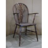 A Windsor elm and beechwood hoop and stick back elbow chair with pierced splat over a saddle