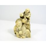 Meiji Period - Ivory Okimono of an aged man with three children, 18cm