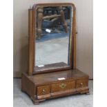 A Georgian walnut toilet mirror with gilt slip and moulded frame raised on simple tapered supports