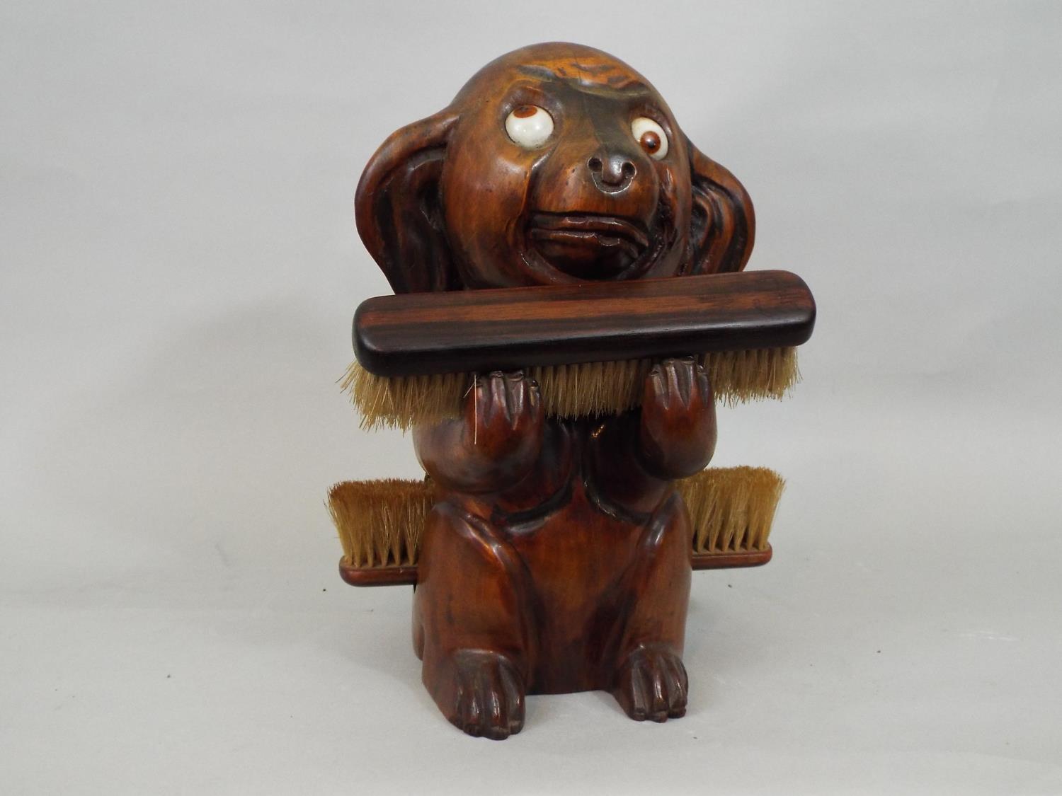 A vintage googly eyed carved timber dog supporting two clothes brushes, 25cm high - Image 2 of 3