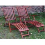A pair of contemporary teak folding steamer type chairs with slatted seats, backs and foot rests