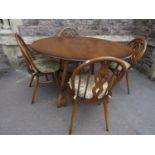 An Ercol medium elm and beechwood oval drop leaf cottage dining table raised on splayed square cut