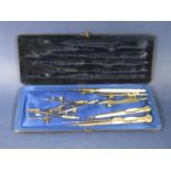 An early 20th century eight piece drawing instrument set in a folding case