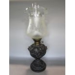 Good quality cast metal oil lamp by Matador Brenner, the base cast with scallop shells and bust