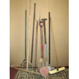 A small collection of long handled tools to include a two pronged pitchfork, a vintage hay rake, two