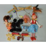A box containing a mixed collection of toys including two string puppets, farm trucks, dolls, etc (
