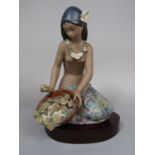 A Lladro Daisa matt glazed model of a kneeling Polynesian style woman holding a basket of flowers,