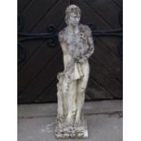 A weathered cast composition stone classical male garden figure/statue in standing pose beside and
