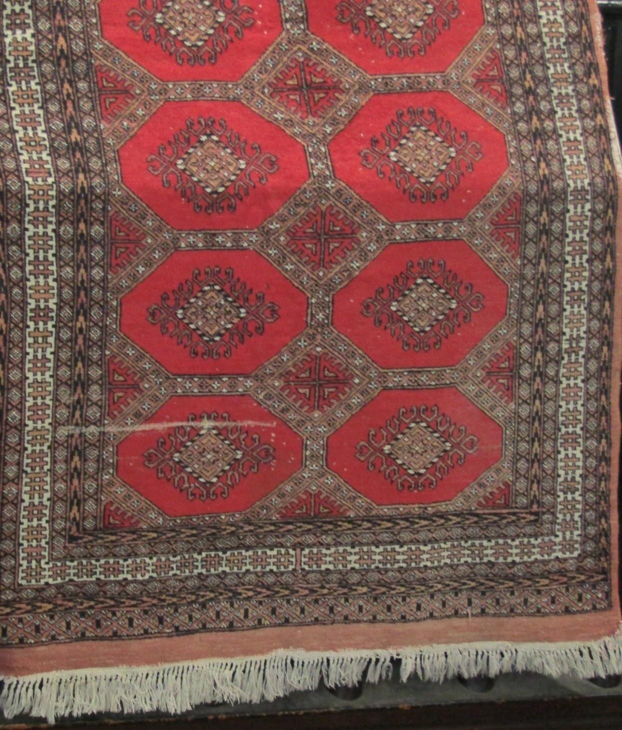 Bokhara type rug with fawn medallions upon a red ground, 200 x 130cm - Image 2 of 4