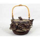 A Japanese iron work kettle, the body of circular form with trailing fruiting vine detail, the lid