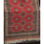 Bokhara type rug with fawn medallions upon a red ground, 200 x 130cm