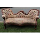 A Victorian style twin spoon back sofa with serpentine shaped floral patterned upholstered seat