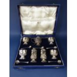 Good quality cased seven piece silver table cruets with half fluted and floral embossed