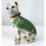 A ceramic model of a seated Pug with floral sprays, green coat and other detail, 32cm tall